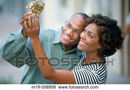 couple looking at a gift View Large Photo Image Stock Photo - couple looking at a gift. Fotosearch