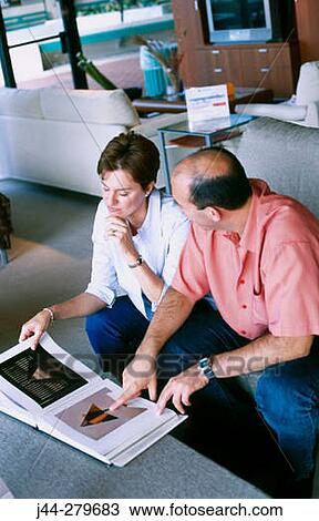 Couple looking at catalog in a furniture store View Large Photo Image Stock Image - Couple looking at catalog in a furniture store. Fotosearch
