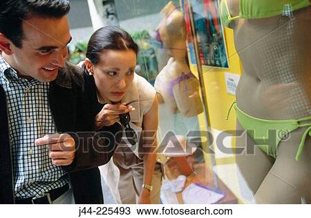 Couple looking at display window in shopping mall View Large Photo Image Stock Image - Couple looking at display window in shopping mall. Fotosearch