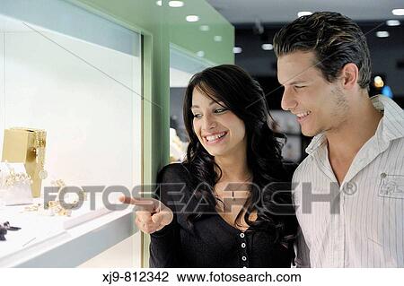 Couple looking at jewellery display View Large Photo Image Stock Image - Couple looking at jewellery display. Fotosearch
