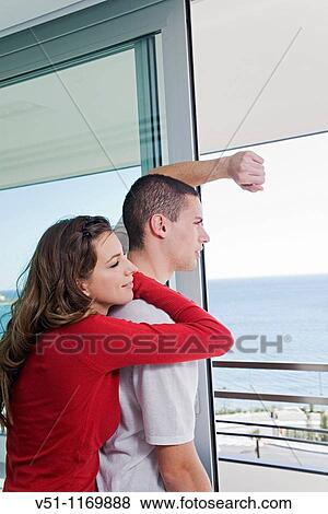 Couple looking at the sea from home View Large Photo Image Stock Photo - Couple looking at the sea from home. Fotosearch