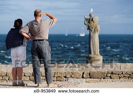 Stock Photo - Couple looking at the sea, Kerpenhir point, town of Locmariaquer, departament of Morbihan, Brittany, France. Fotosearch