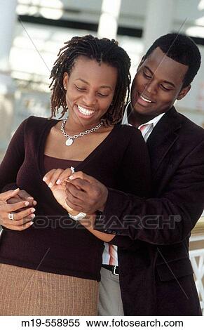 Stock Photography - couple looking at their engagment ring. Fotosearch