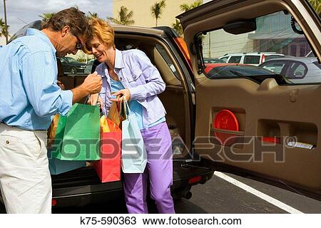 Stock Image - Couple looking at their purchases. Fotosearch