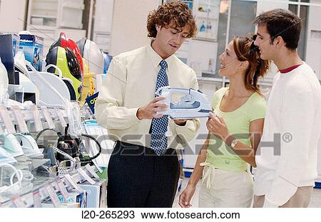 Couple looking for an iron at shopping center View Large Photo Image Stock Image - Couple looking for an iron at shopping center. Fotosearch
