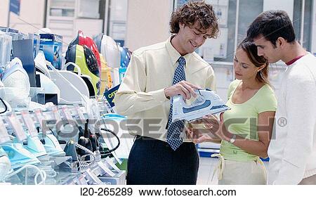 Couple looking for an iron at shopping center View Large Photo Image Stock Photo - Couple looking for an iron at shopping center. Fotosearch