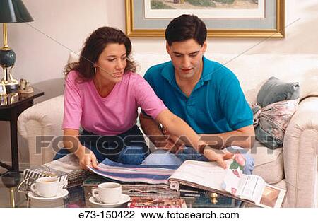 Stock Image - Couple looking through wallpaper and carpet. Fotosearch