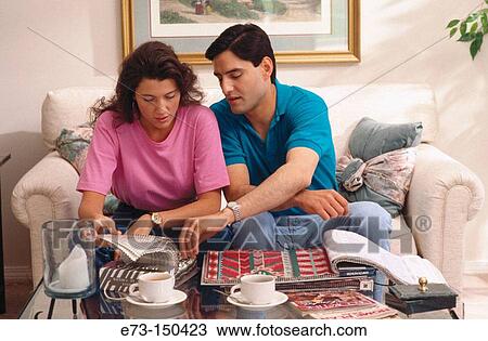 Stock Image - Couple looking through wallpaper and carpet. Fotosearch