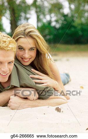 Couple lying down in the beach View Large Photo Image Stock Photography - Couple lying down in the beach. Fotosearch