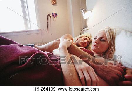Stock Photo - Couple lying in bed. Fotosearch