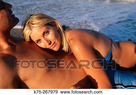 Couple lying in the surf View Large Photo Image Stock Photo - Couple lying in the surf. Fotosearch