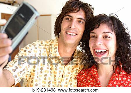 Stock Photo - Couple making themselves a photo with a mobile phone. Fotosearch