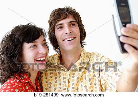 Couple making themselves a photo with a mobile phone View Large Photo Image Stock Photo - Couple making themselves a photo with a mobile phone. Fotosearch