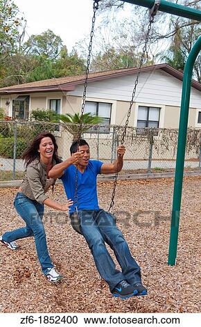 Couple multi ethnics dating in park on swing with fun and Asian Hispanic ethnic laughter near home in playground View Large Photo Image Stock Image - Couple multi ethnics dating in park on swing with fun and Asian Hispanic ethnic laughter near home in playground. Fotosearch