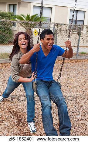 Couple multi ethnics dating in park on swing with fun and Asian Hispanic ethnic laughter near home in playground View Large Photo Image Stock Image - Couple multi ethnics dating in park on swing with fun and Asian Hispanic ethnic laughter near home in playground. Fotosearch