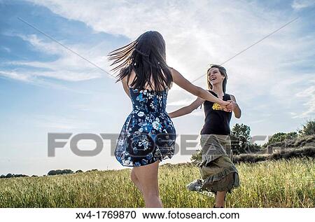 Couple of girls dancing and enjoyment in the countryside View Large Photo Image Stock Image - Couple of girls dancing and enjoyment in the countryside. Fotosearch