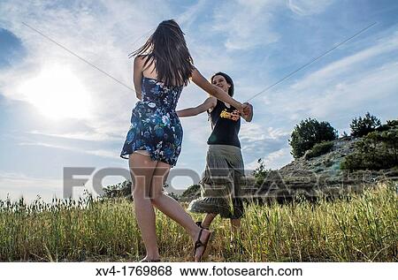 Stock Photo - Couple of girls dancing and enjoyment in the countryside. Fotosearch