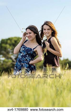 Couple of girls playing and enjoyment whit flowers in the countryside View Large Photo Image Stock Image - Couple of girls playing and enjoyment whit flowers in the countryside. Fotosearch