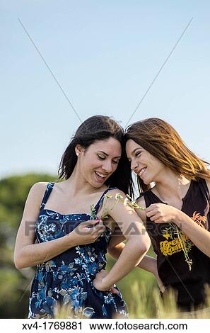 Couple of girls playing and enjoyment whit flowers in the countryside View Large Photo Image Stock Image - Couple of girls playing and enjoyment whit flowers in the countryside. Fotosearch