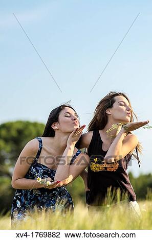 Couple of girls playing and enjoyment whit flowers in the countryside View Large Photo Image Stock Image - Couple of girls playing and enjoyment whit flowers in the countryside. Fotosearch