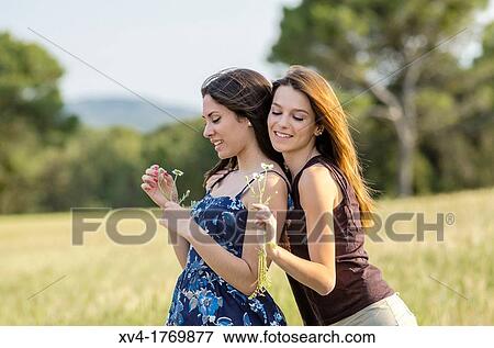 Couple of girls playing and enjoyment whit flowers in the countryside View Large Photo Image Stock Photo - Couple of girls playing and enjoyment whit flowers in the countryside. Fotosearch