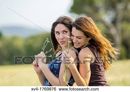 Couple of girls playing and enjoyment whit flowers in the countryside View Large Photo Image Stock Photograph - Couple of girls playing and enjoyment whit flowers in the countryside. Fotosearch