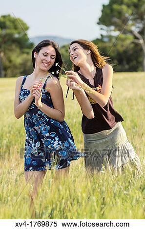 Couple of girls playing and enjoyment whit flowers in the countryside View Large Photo Image Stock Photography - Couple of girls playing and enjoyment whit flowers in the countryside. Fotosearch