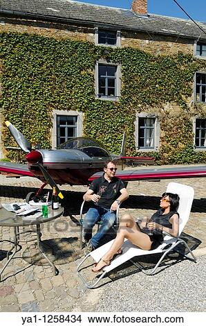 Couple of microlight pilots plane Zenair 601 taking a rest in farm yard after a flight, Belgium View Large Photo Image Picture - Couple of microlight pilots plane Zenair 601 taking a rest in farm yard after a flight, Belgium. Fotosearch
