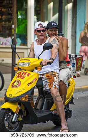 Couple on a moped View Large Photo Image Stock Photography - Couple on a moped. Fotosearch