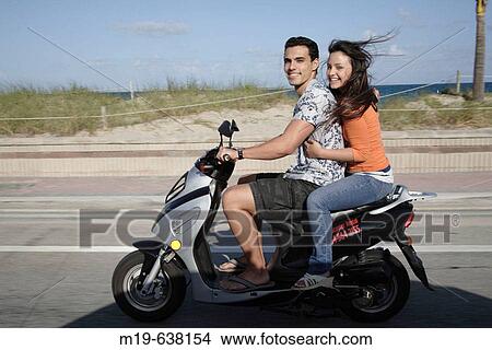 Couple on a scooter View Large Photo Image Picture - Couple on a scooter. Fotosearch