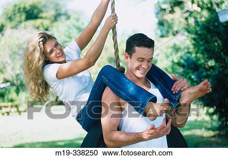 Stock Image - couple on a tire swing. Fotosearch