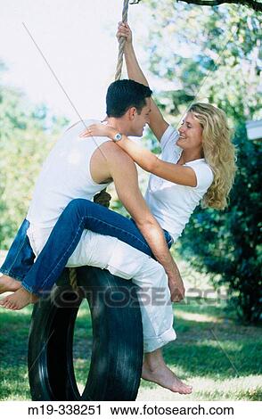 Stock Image - couple on a tire swing. Fotosearch