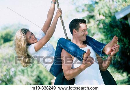 Stock Photo - couple on a tire swing. Fotosearch