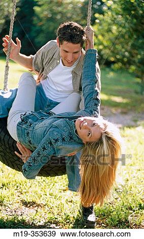 Stock Photo - couple on a tire swing. Fotosearch