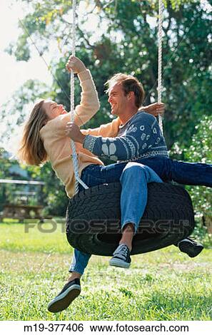 couple on a tire swing View Large Photo Image Stock Photograph - couple on a tire swing. Fotosearch