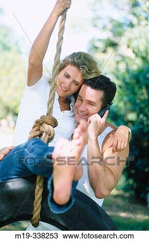 couple on a tire swing with cell phone View Large Photo Image Stock Image - couple on a tire swing with cell phone. Fotosearch