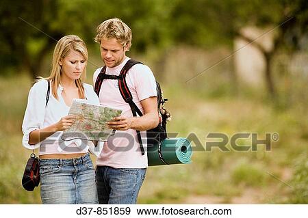 Stock Photo - Couple on country holidays looking at a map. Fotosearch
