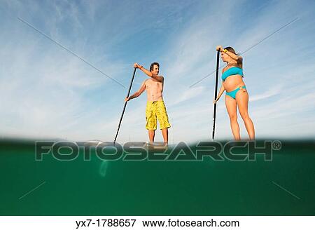 Stock Photo - Couple on stand up paddle boards.. Fotosearch