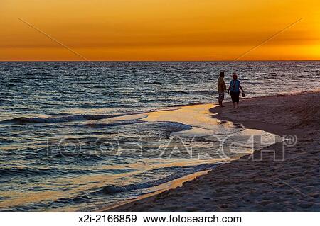 Stock Photo - Couple on the beach during sunset at Gulf Shores, Alabama.. Fotosearch