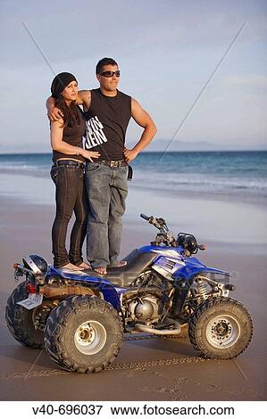 Couple on the beach with quad View Large Photo Image Stock Photo - Couple on the beach with quad. Fotosearch