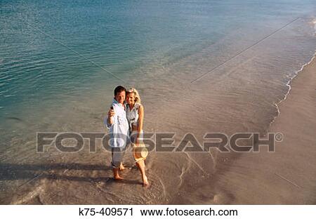 Stock Image - couple on vacation using camera phone. Fotosearch