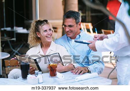 Couple ordering food in a restaurant View Large Photo Image Stock Photo - Couple ordering food in a restaurant. Fotosearch