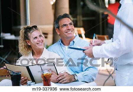 Couple ordering food in a restaurant View Large Photo Image Stock Photograph - Couple ordering food in a restaurant. Fotosearch