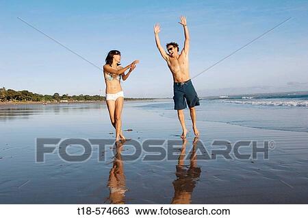 couple playing and jumping on beach View Large Photo Image Stock Image - couple playing and jumping on beach. Fotosearch
