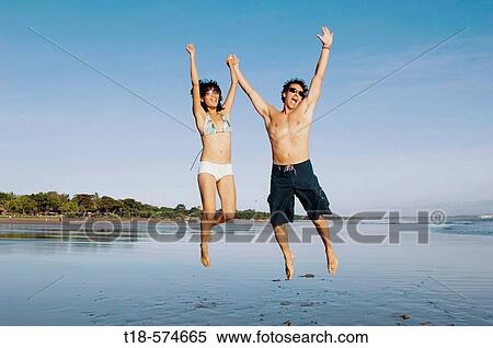couple playing and jumping on beach View Large Photo Image Stock Photography - couple playing and jumping on beach. Fotosearch