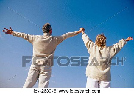 Stock Photograph - Couple raising arms. Fotosearch