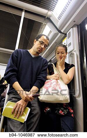 Couple reading a message on the mobile phone in the subway, Barcelona. Catalonia, Spain View Large Photo Image Stock Photo - Couple reading a message on the mobile phone in the subway, Barcelona. Catalonia, Spain. Fotosearch