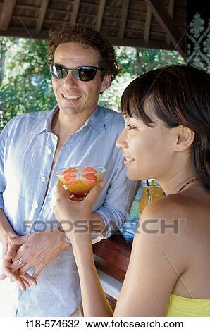 Stock Image - couple relaxing and drinking at bar. Fotosearch