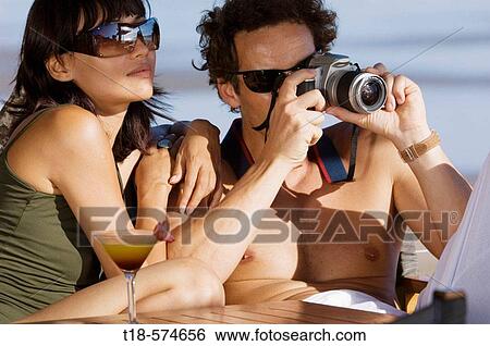 couple relaxing and taking snapshot View Large Photo Image Stock Photograph - couple relaxing and taking snapshot. Fotosearch