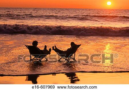 Couple relaxing at the beach View Large Photo Image Stock Photo - Couple relaxing at the beach. Fotosearch
